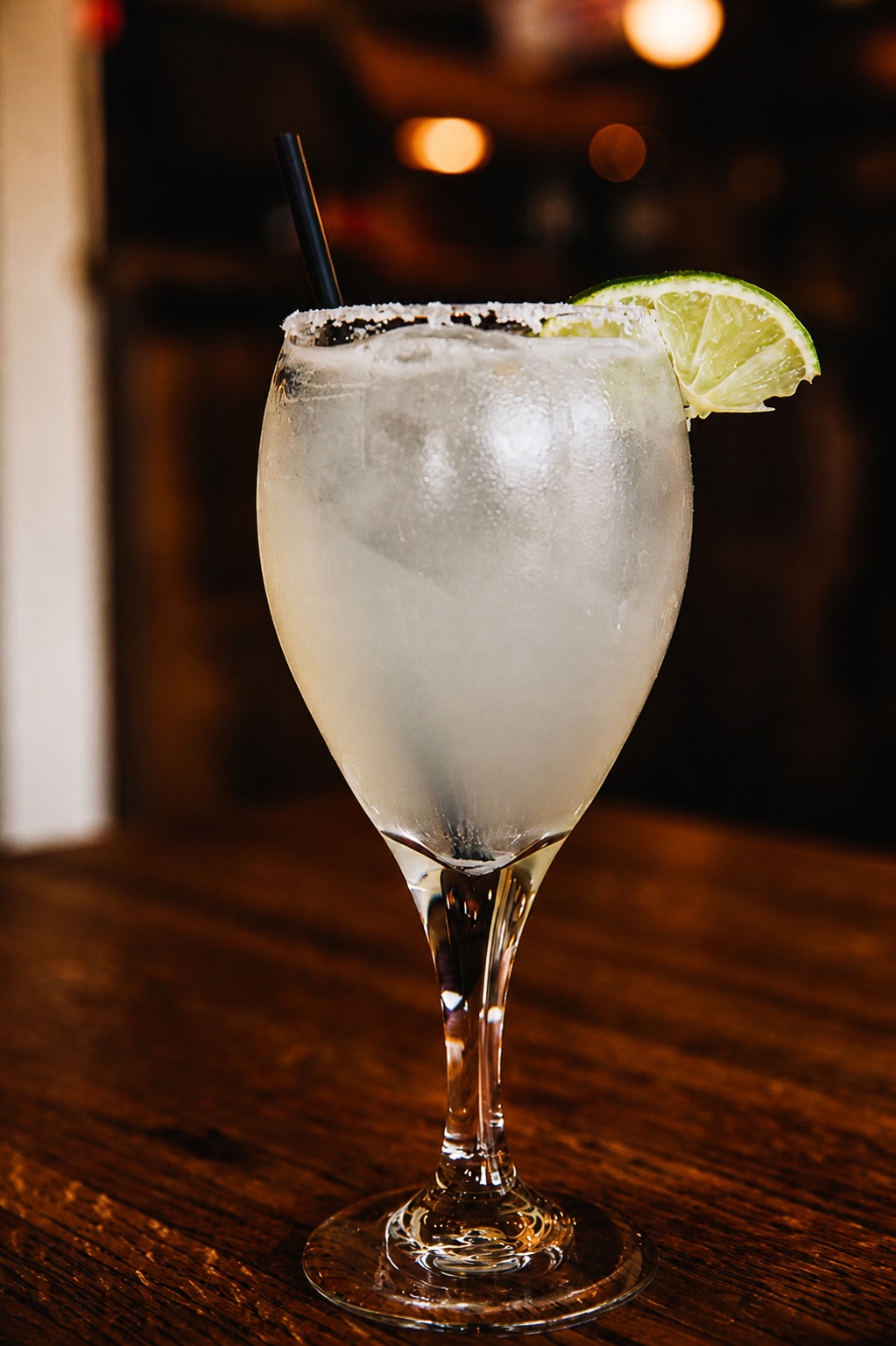 Salt-rimmed Mexicali margarita with a fresh lime wedge