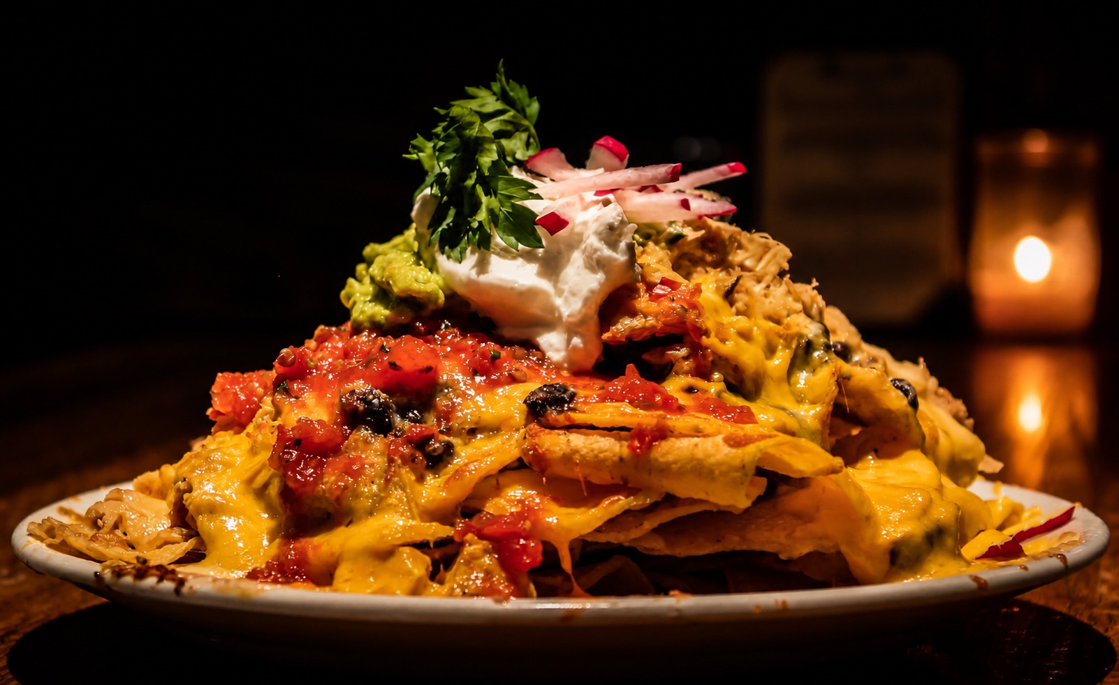 A generous plate of Mexicali nachos with cheese, salsa and fresh toppings